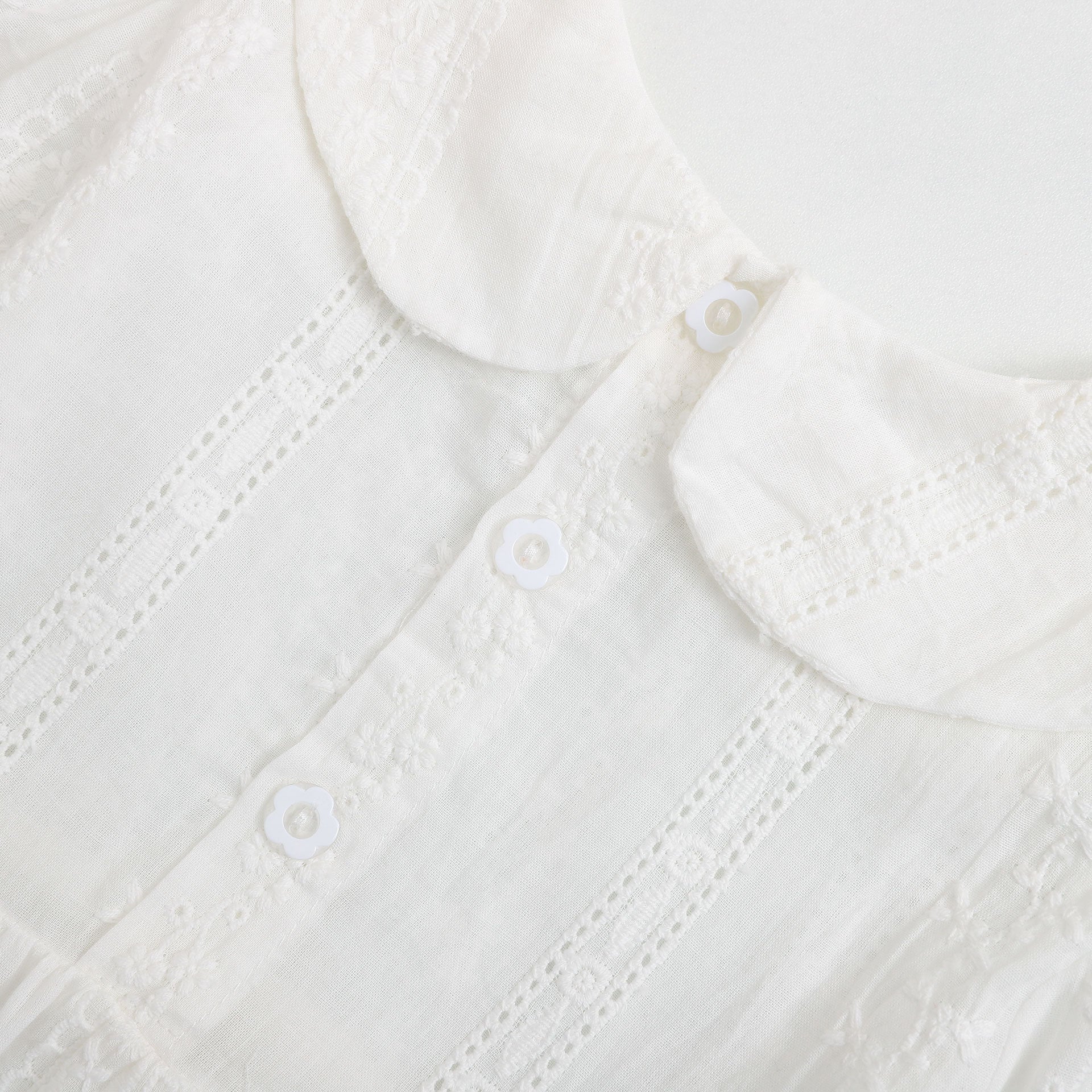 A beautiful baby girl dress made of white mesh fabric featuring an elegant embroidered pattern and long sleeves, perfect for special occasions.