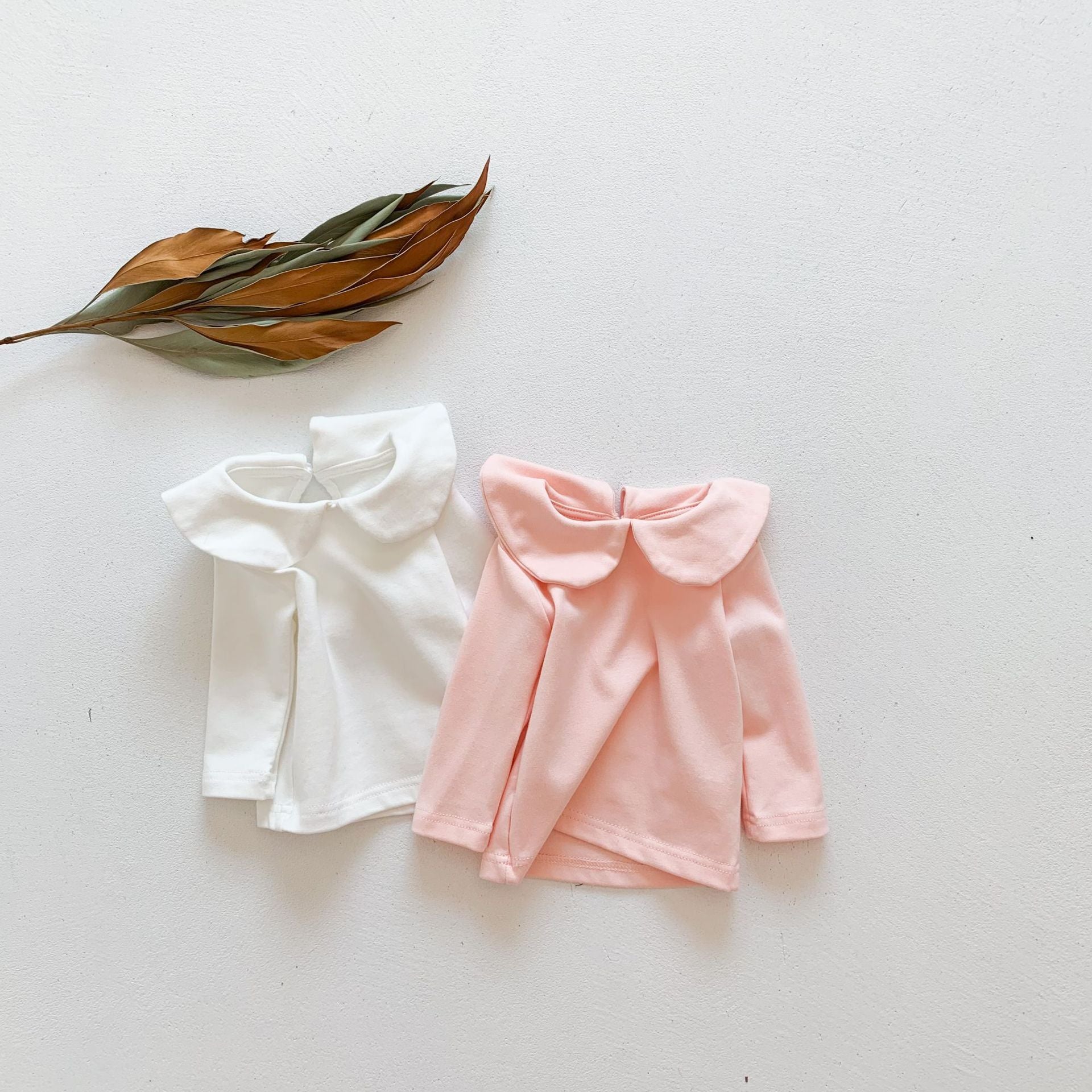 Baby girl solid doll collar top in white and pink, made from soft cotton blend, featuring a fitted silhouette and distinctive collar.