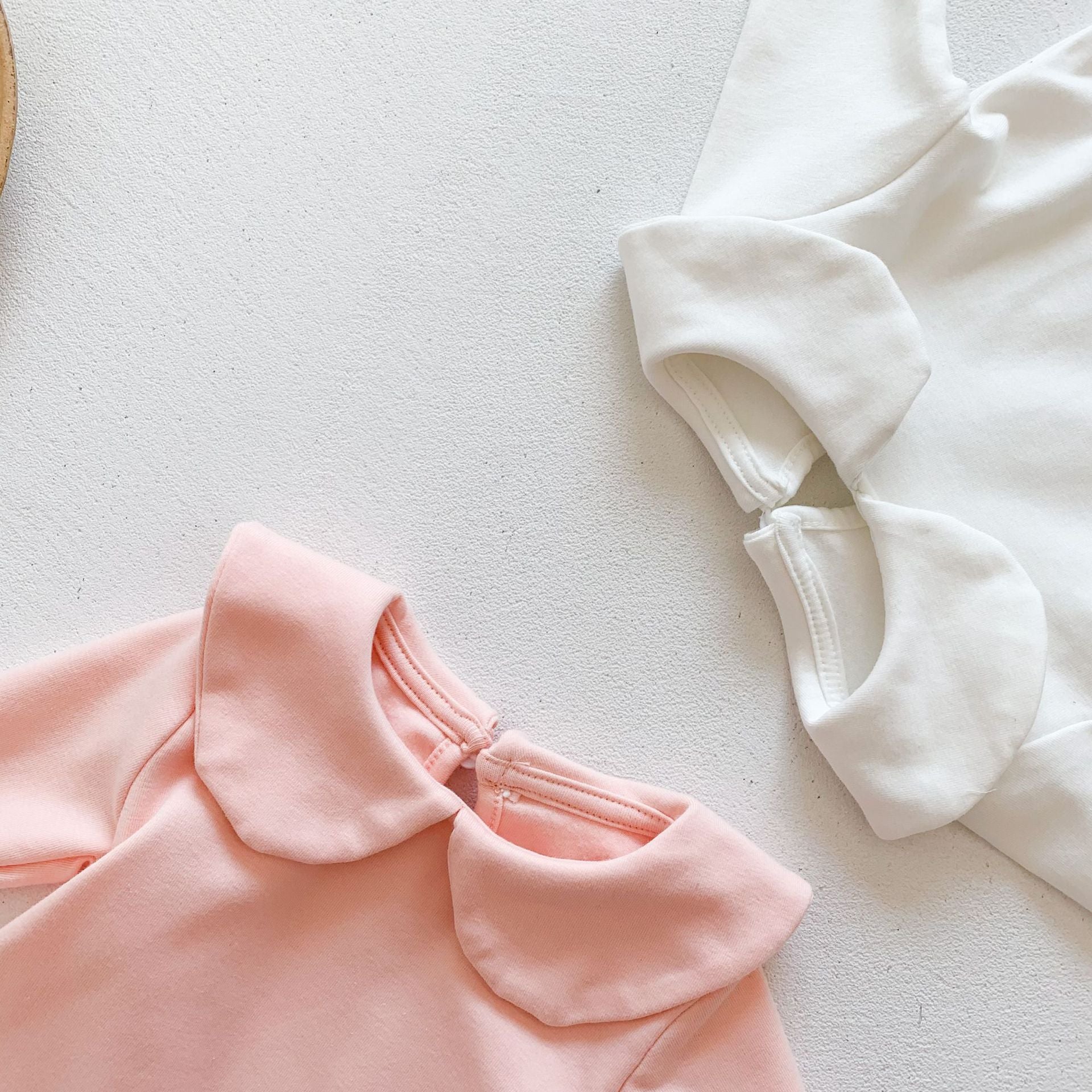 Baby girl solid doll collar top in white and pink, made from soft cotton blend, featuring a fitted silhouette and distinctive collar.