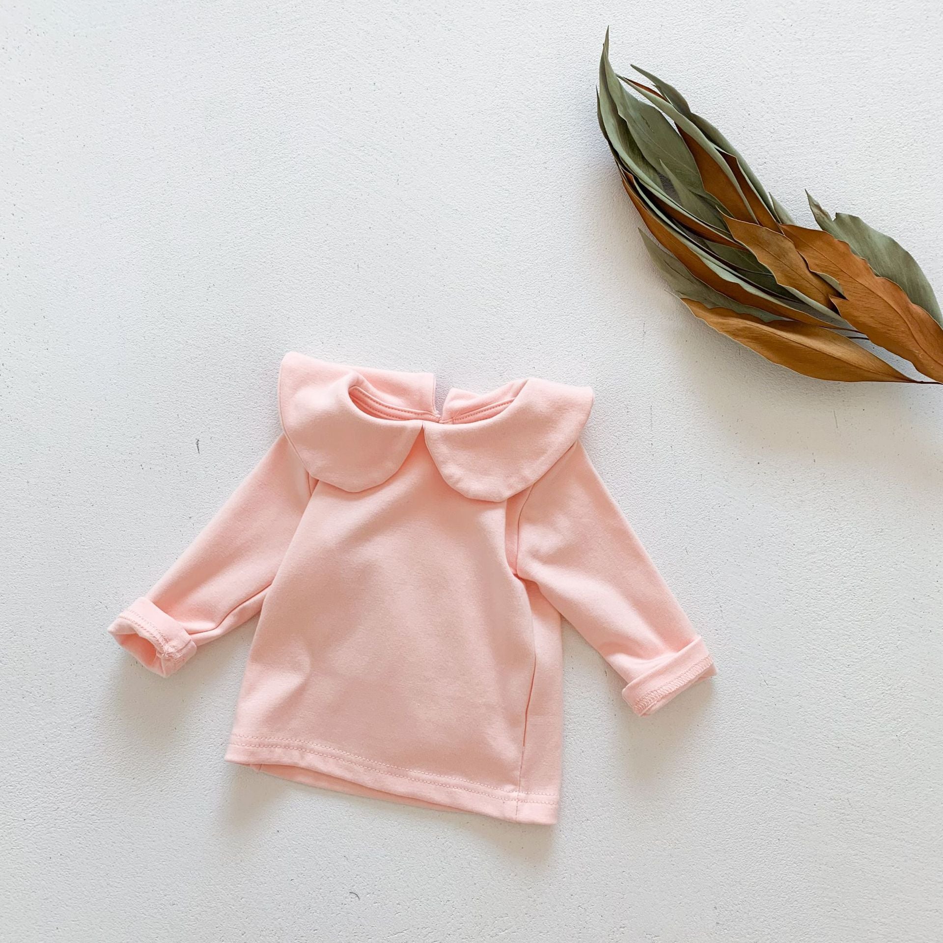 Baby girl solid doll collar top in white and pink, made from soft cotton blend, featuring a fitted silhouette and distinctive collar.