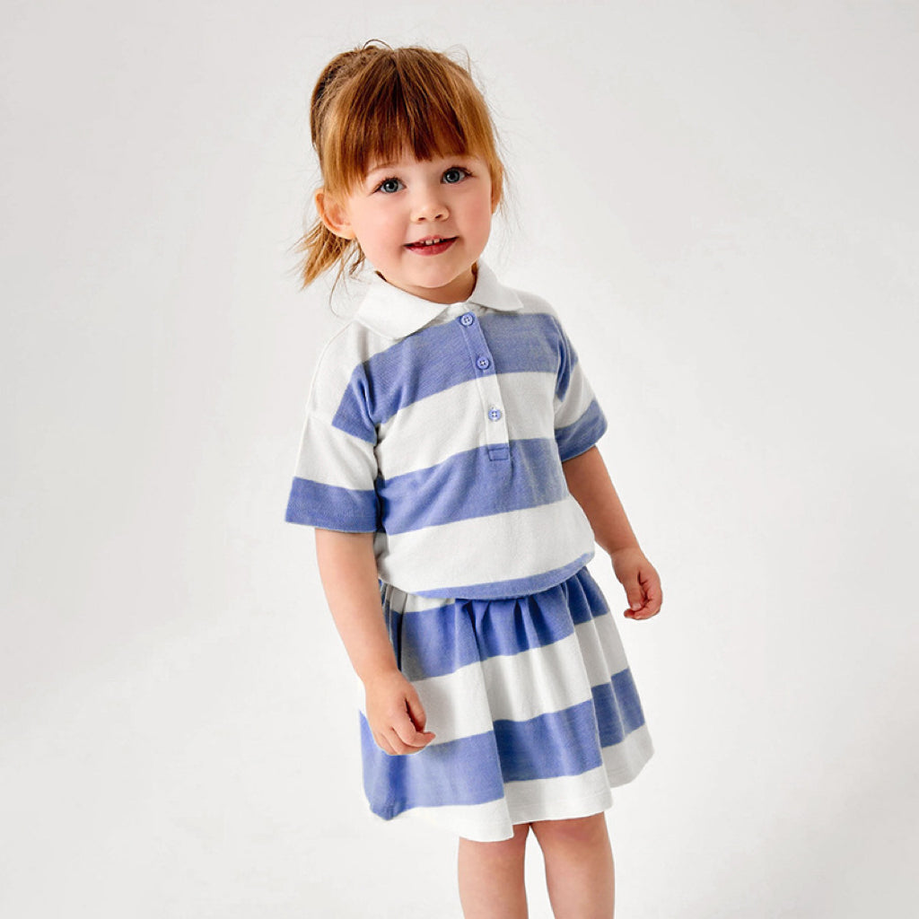 Baby girl wearing a blue striped polo neck shirt with a pleated skirt, perfect for summer outings.