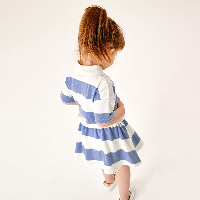 Baby girl wearing a blue striped polo neck shirt with a pleated skirt, perfect for summer outings.