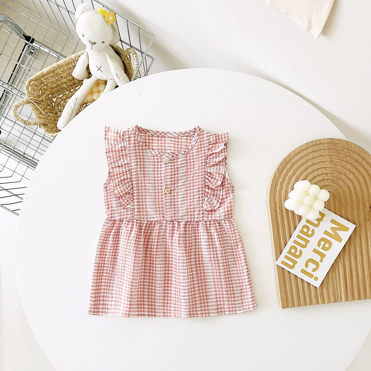 A variety of baby girl summer dresses in floral and plaid patterns, showcasing vibrant colors like pink, blue, and yellow.