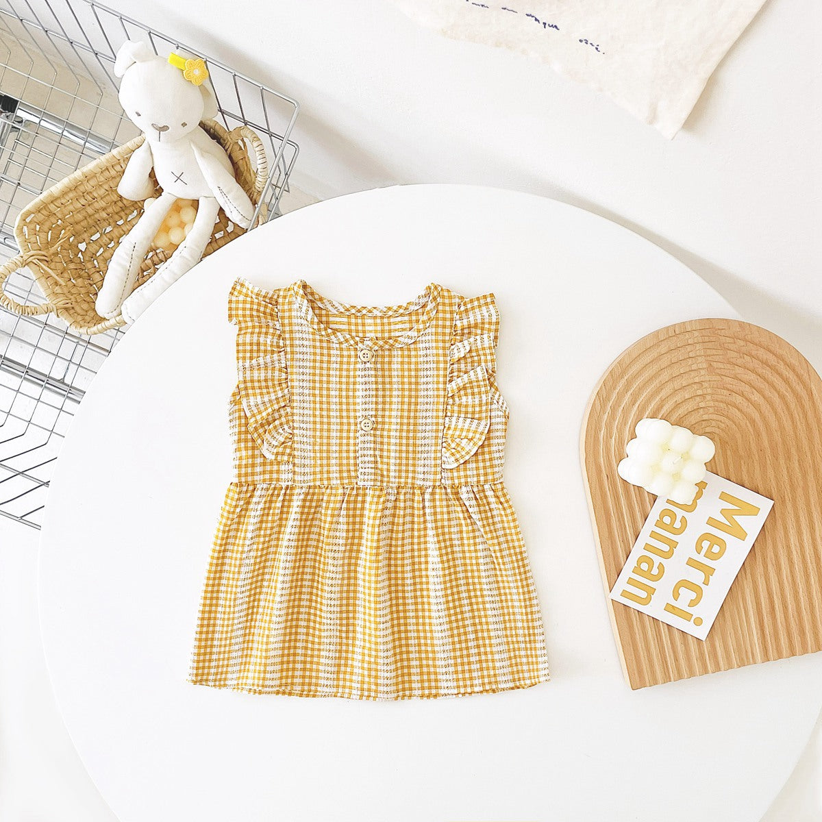 A variety of baby girl summer dresses in floral and plaid patterns, showcasing vibrant colors like pink, blue, and yellow.