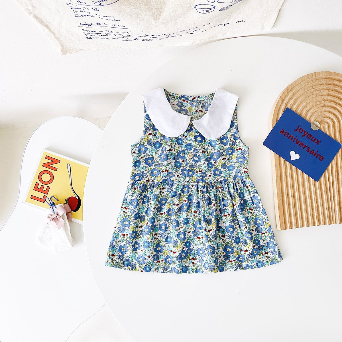 A variety of baby girl summer dresses in floral and plaid patterns, showcasing vibrant colors like pink, blue, and yellow.