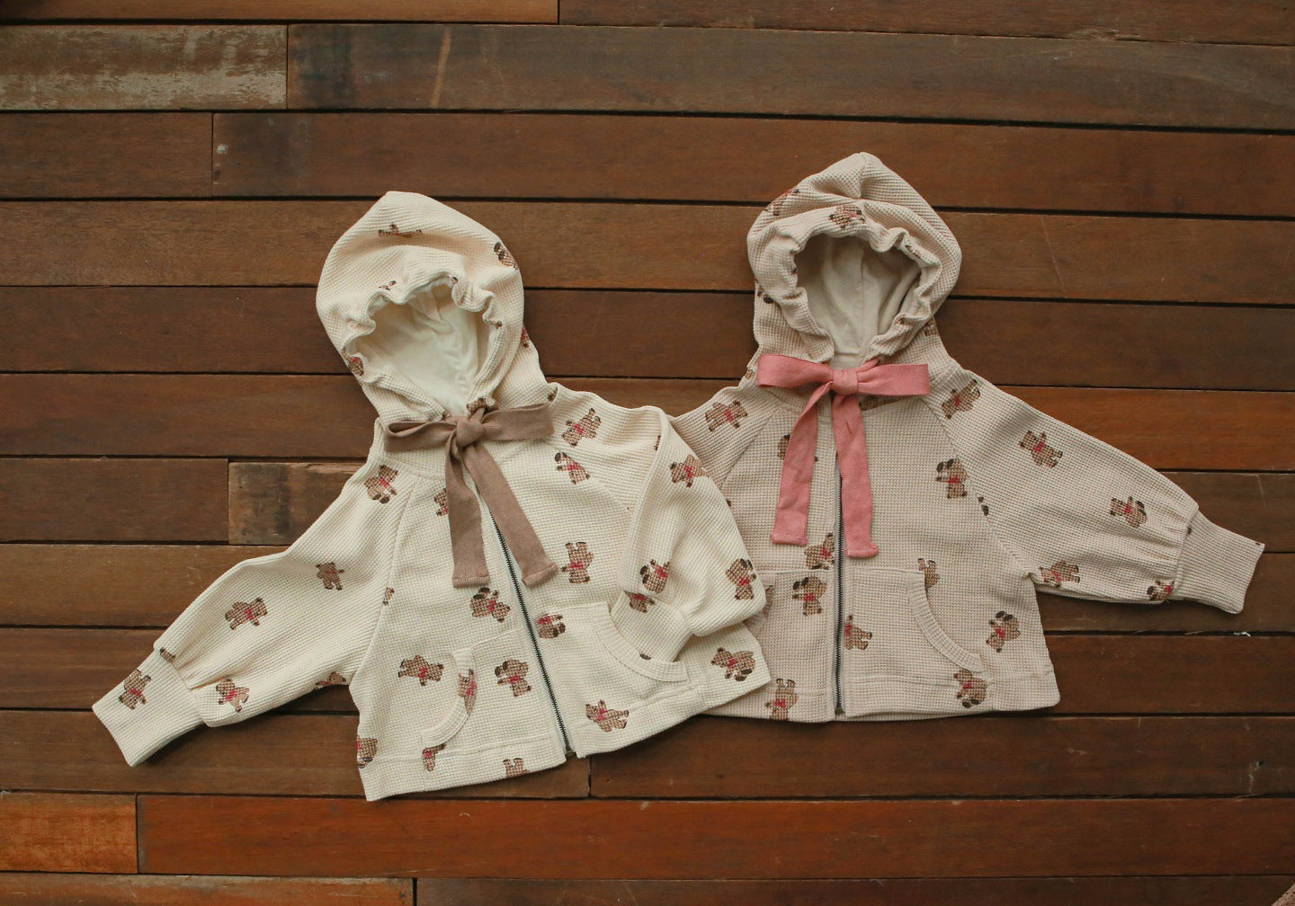 Baby girl wearing a cozy bear pattern waffle knit jacket coat with a hood, showcasing khaki color and zipper design.