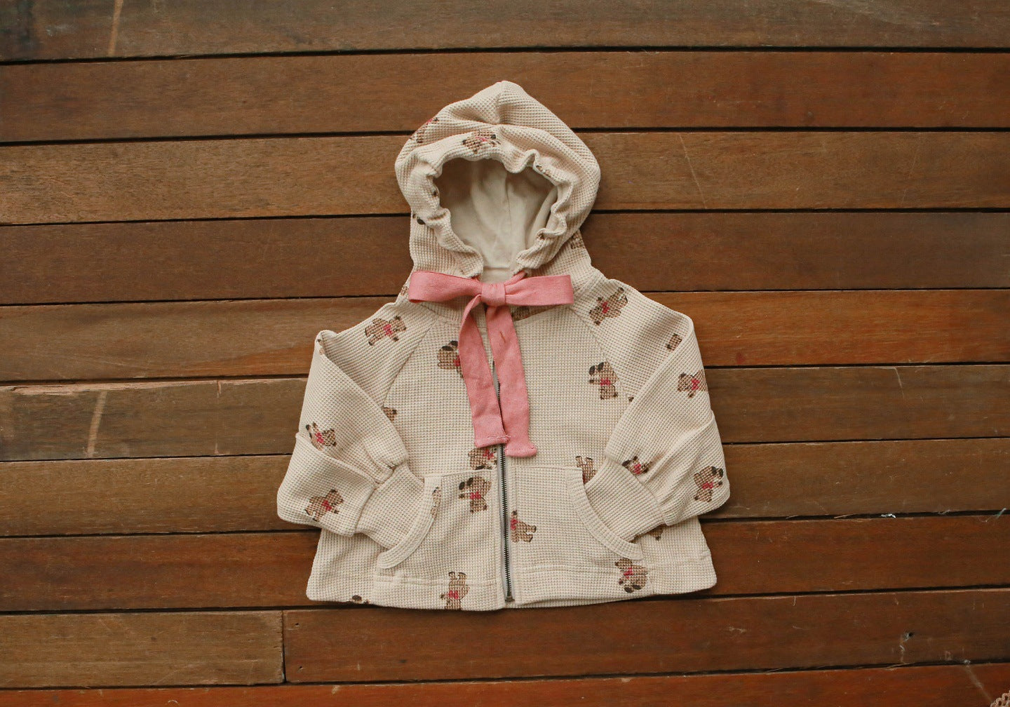 Baby girl wearing a cozy bear pattern waffle knit jacket coat with a hood, showcasing khaki color and zipper design.