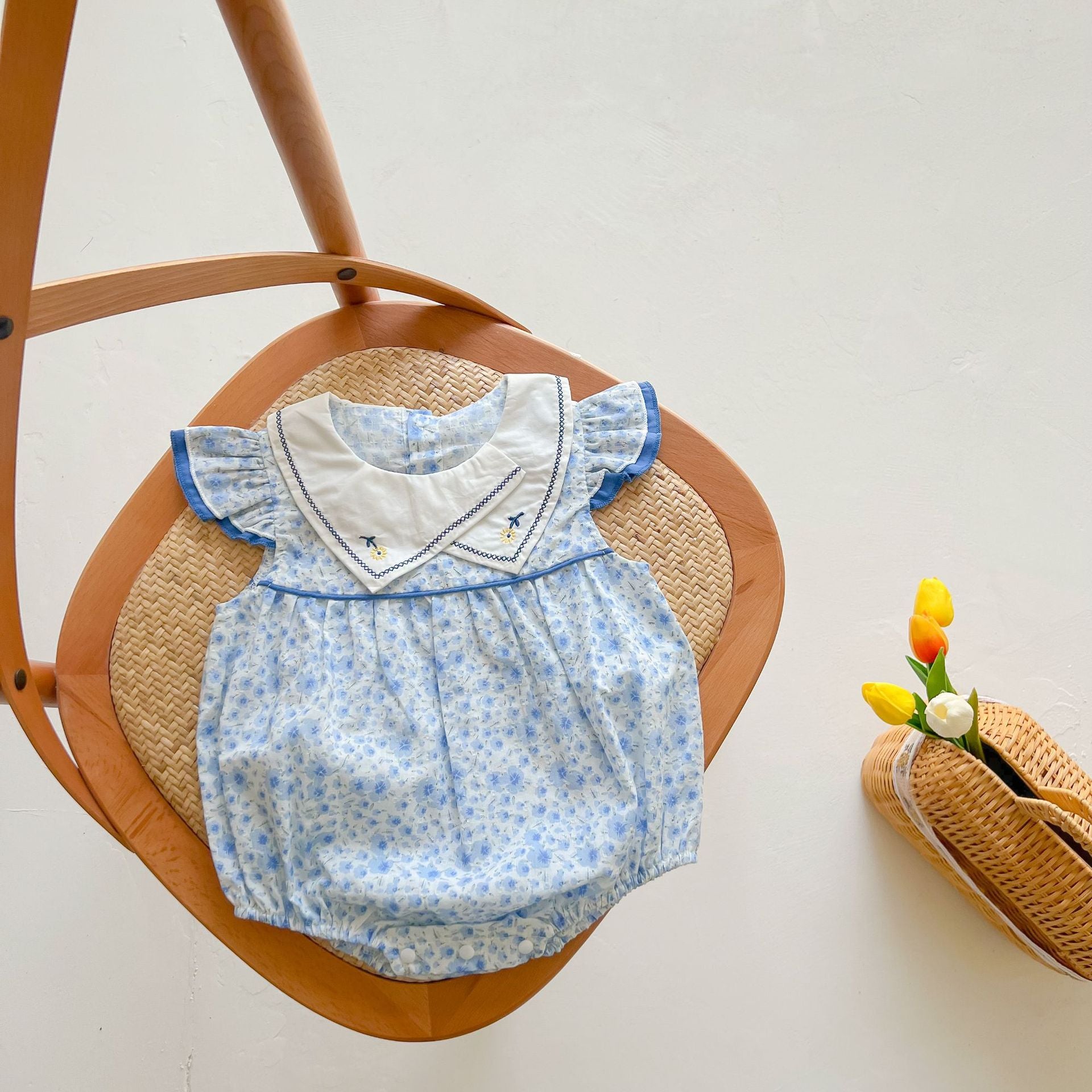 Baby girls floral print onesie with embroidered design and ruffle sleeves in blue, perfect for summer wear.