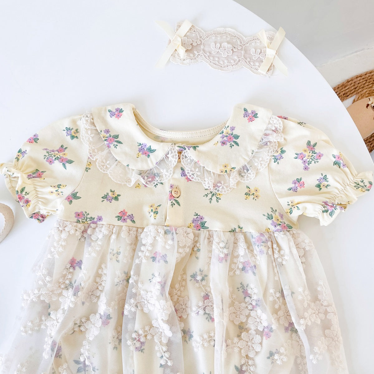 Baby girls floral print dress with embroidered lace patchwork and doll-neck design in apricot color.