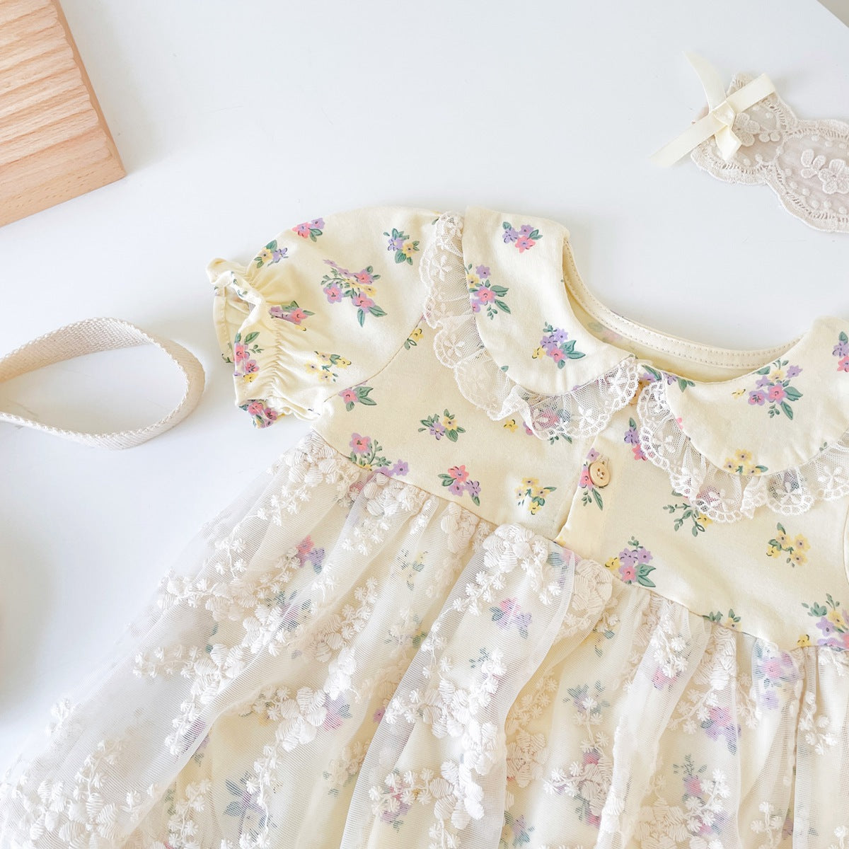 Baby girls floral print dress with embroidered lace patchwork and doll-neck design in apricot color.