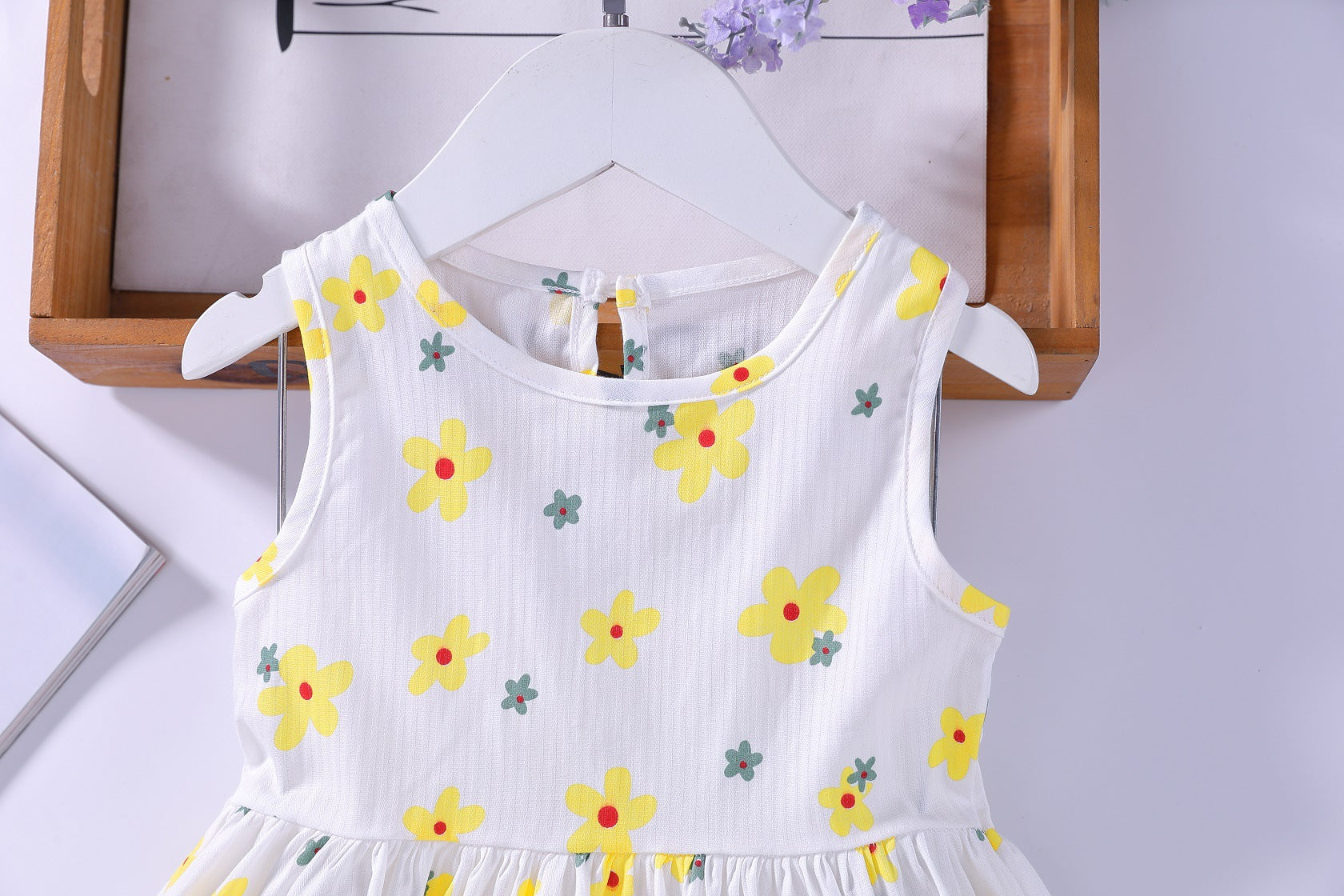 A beautiful baby girls floral print sleeveless dress featuring vibrant colors and a round collar, perfect for summer occasions.