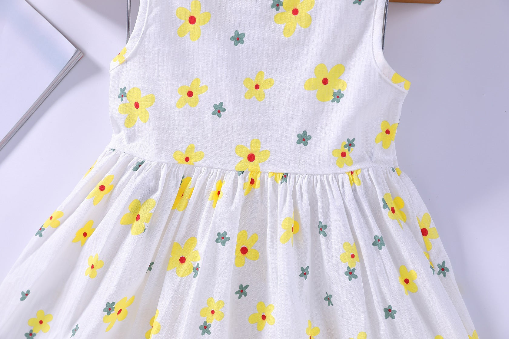 A beautiful baby girls floral print sleeveless dress featuring vibrant colors and a round collar, perfect for summer occasions.