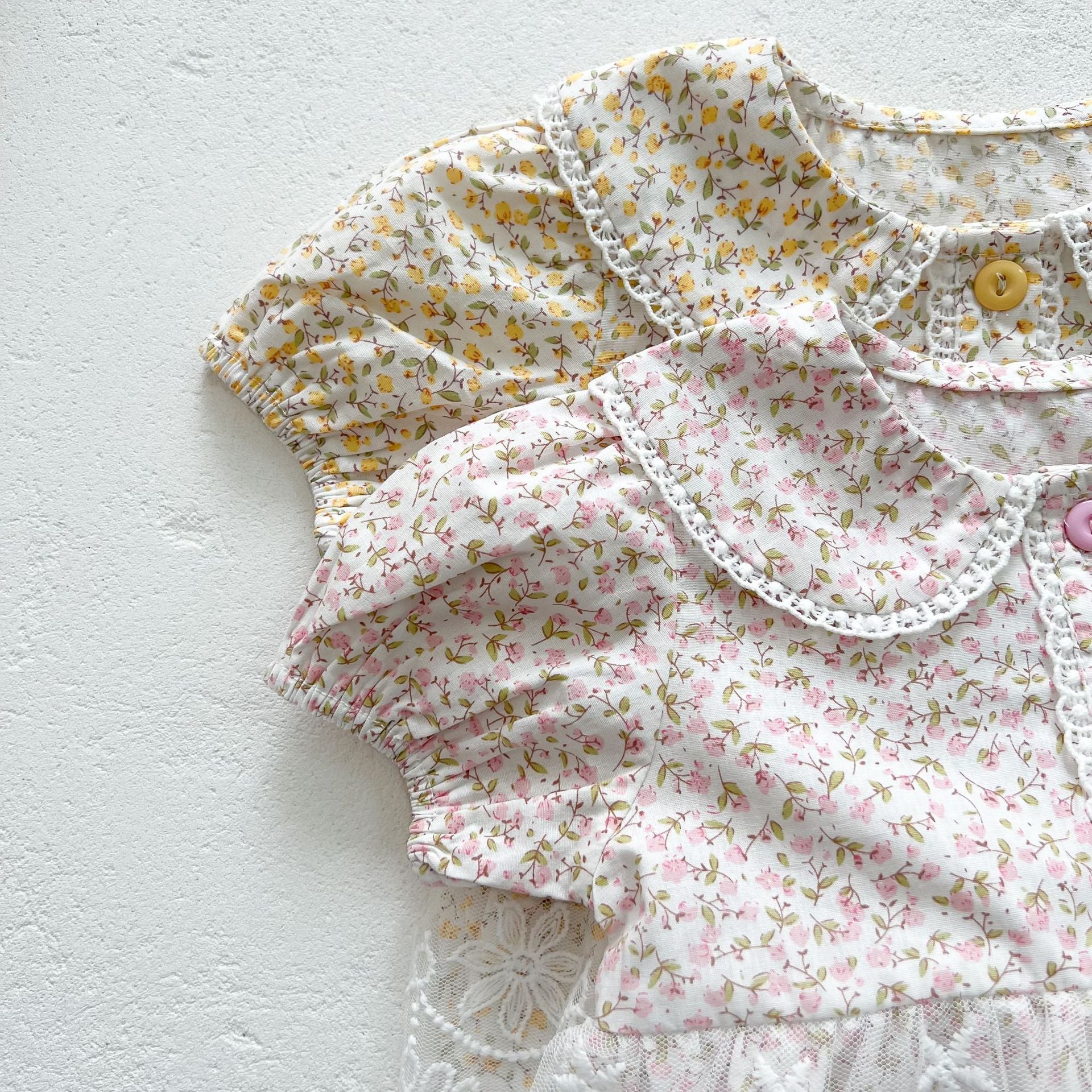 Baby girls floral print onesie featuring a doll collar and gauze skirt, available in pink and yellow.