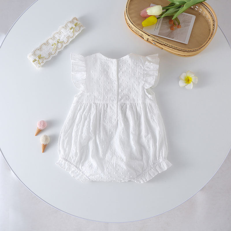 Baby girl wearing a solid white onesie with a gold bow tie patch, perfect for summer outings.