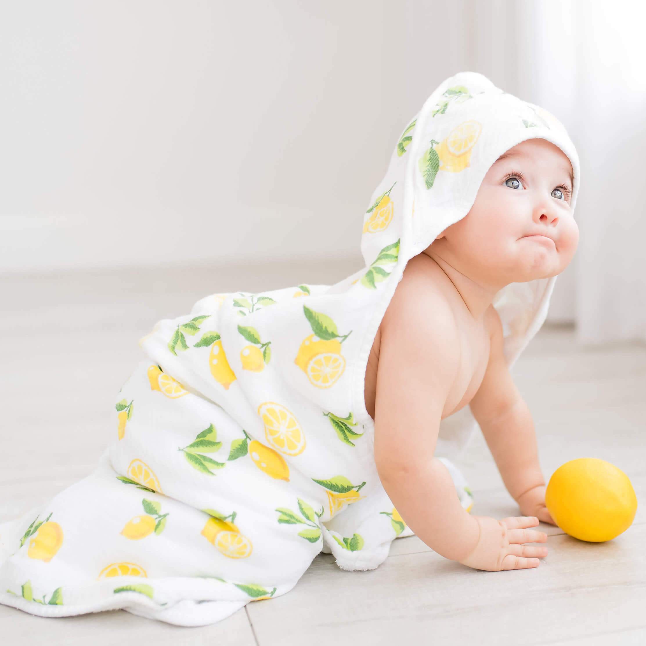 Baby hooded towel featuring a lemon print, made from buttery soft terry and muslin-backed organic bamboo, perfect for newborns to toddlers.