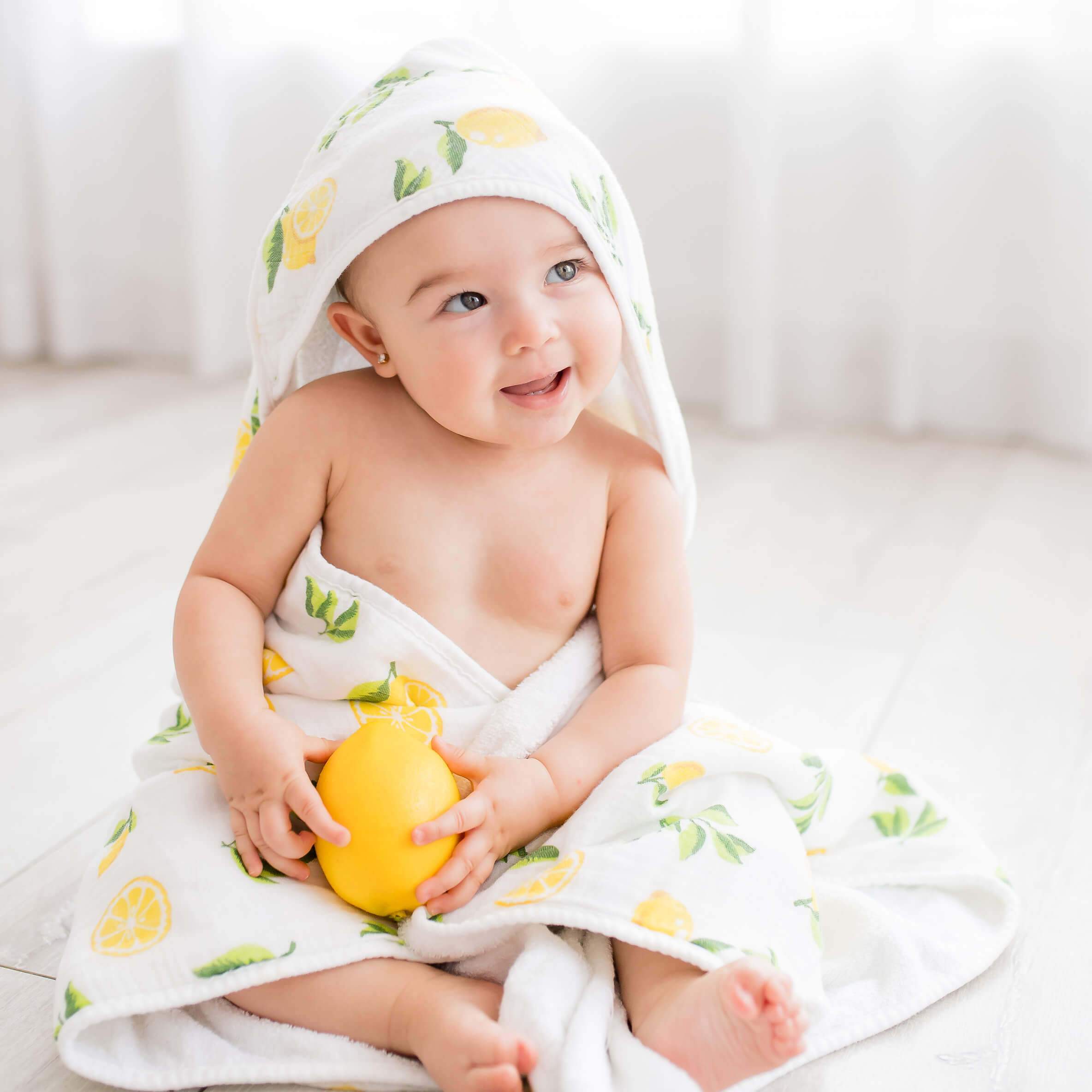 Baby hooded towel featuring a lemon print, made from buttery soft terry and muslin-backed organic bamboo, perfect for newborns to toddlers.