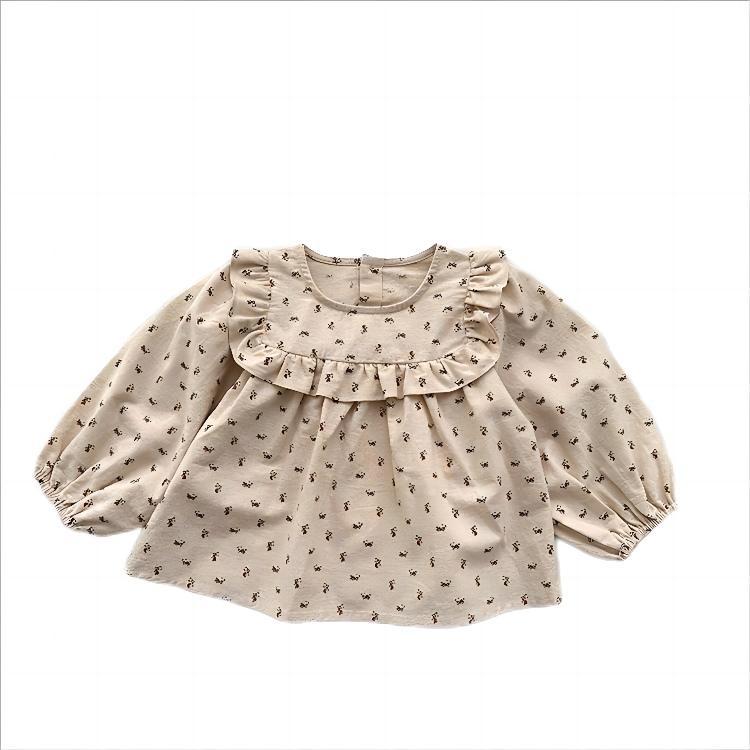 Baby girl wearing a floral print crew neck long sleeve top in apricot color, showcasing countryside style.