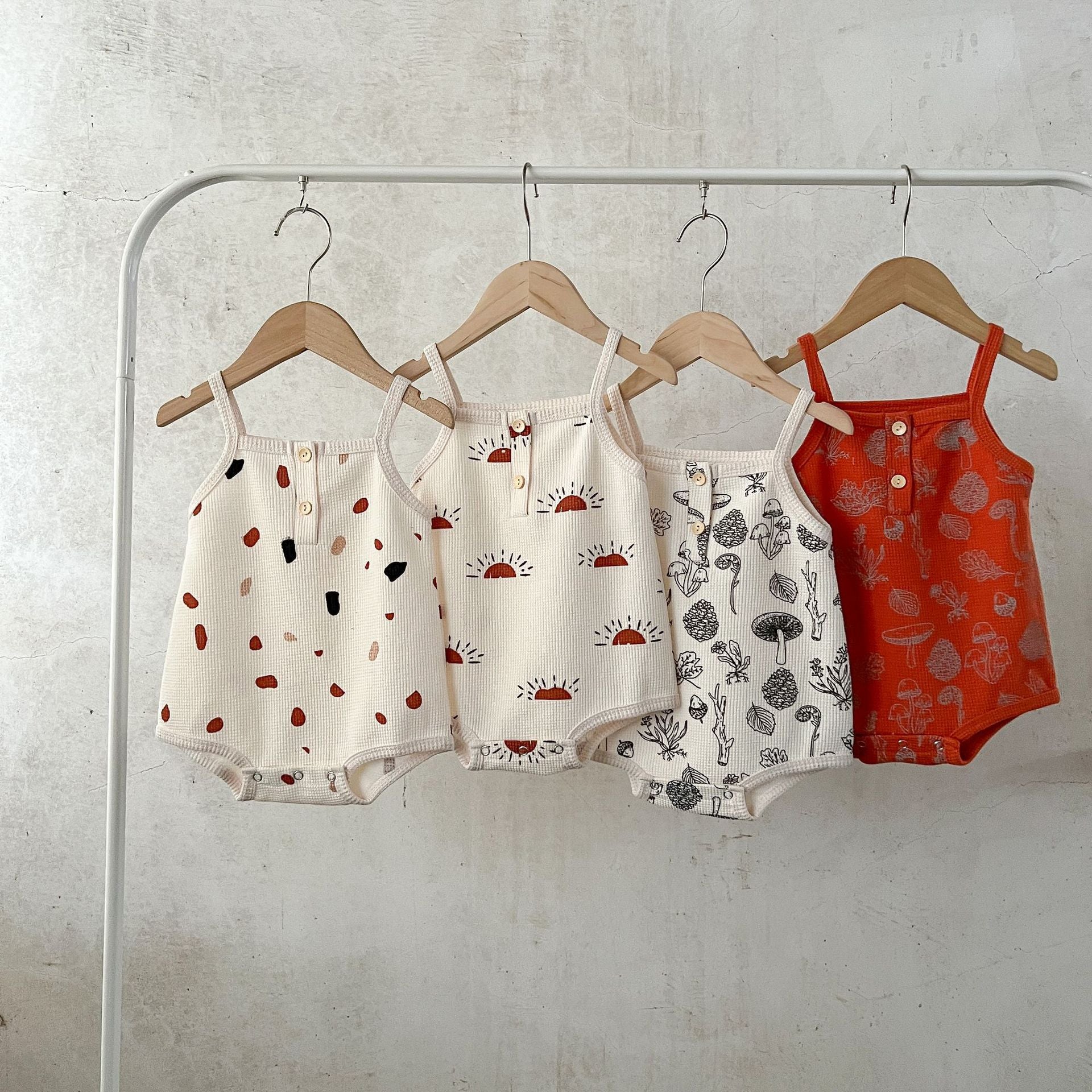 A collection of Baby Multi-Pattern Sling Soft Cotton Loose Casual Onesies in various colors and patterns, showcasing their soft fabric and stylish design.