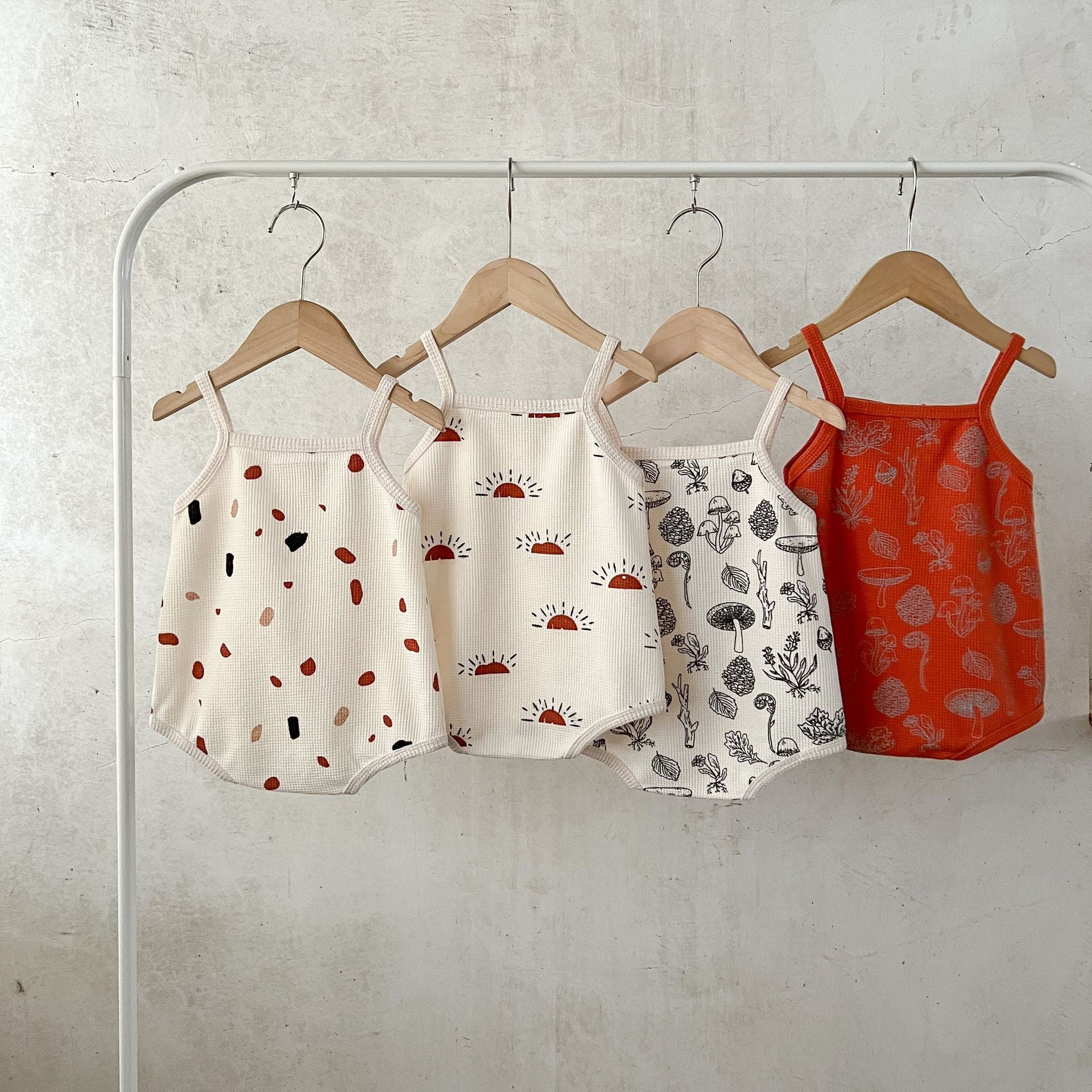 A collection of Baby Multi-Pattern Sling Soft Cotton Loose Casual Onesies in various colors and patterns, showcasing their soft fabric and stylish design.