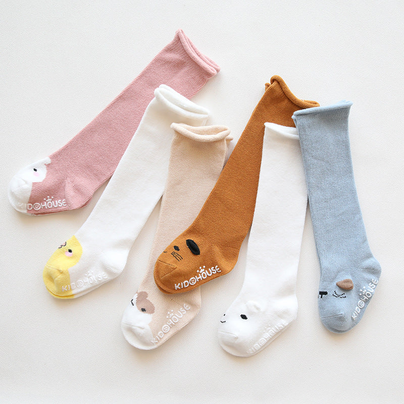 A pair of baby non-slip over the knee soft cotton high tube socks featuring cute animal and cartoon patterns, ideal for comfort and safety.