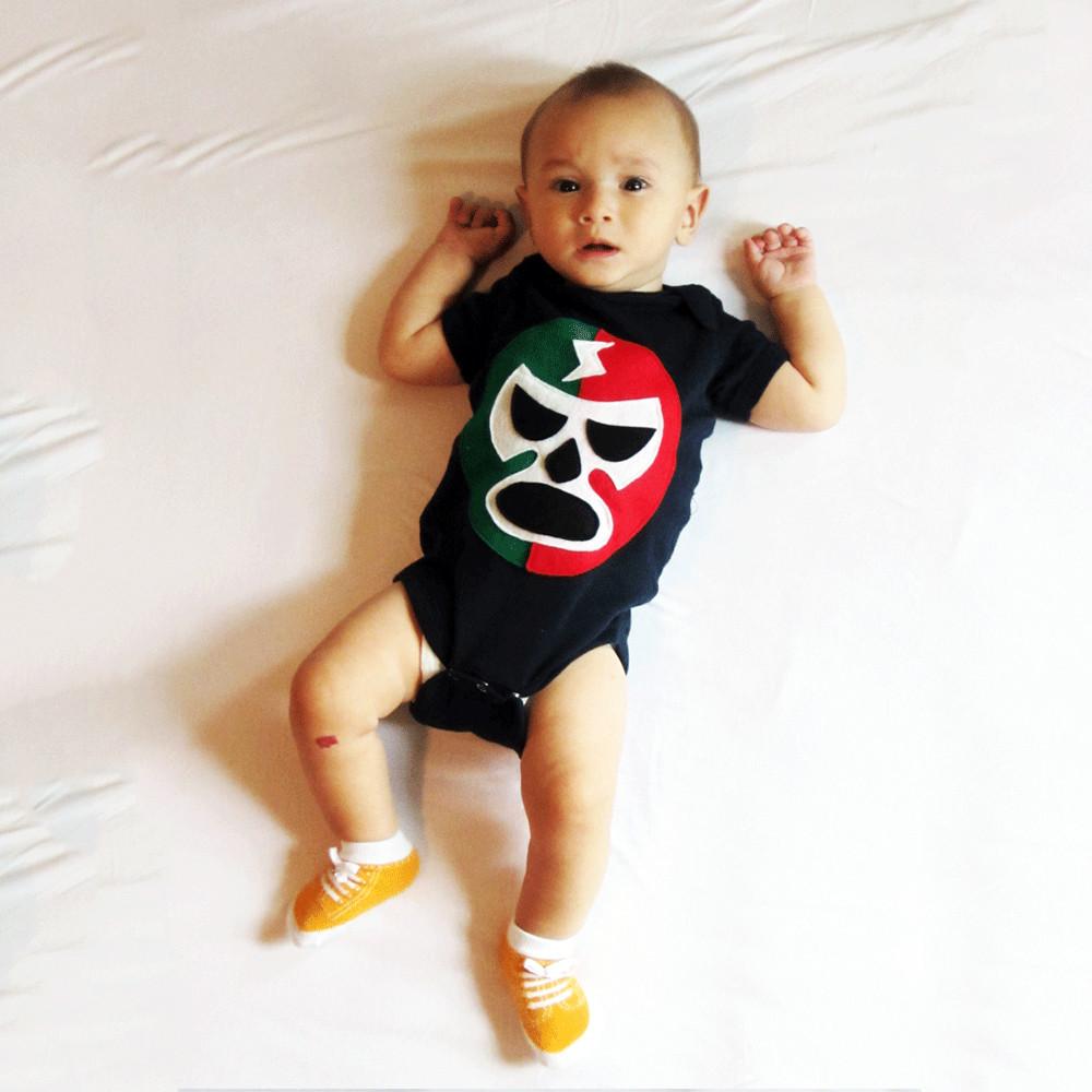 A vibrant baby onesie featuring a red and green luchador design, handmade with felt appliqués, perfect for infants.