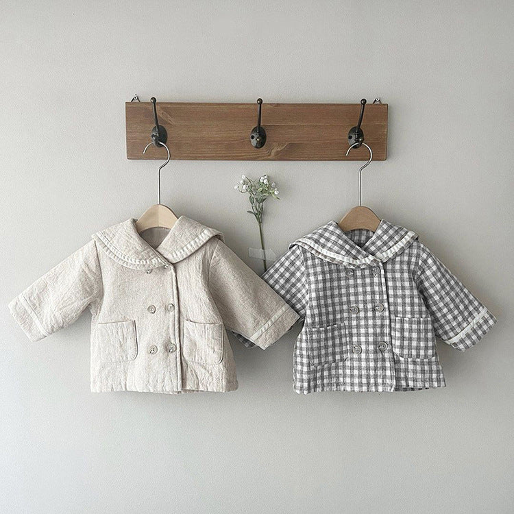 A stylish baby quilted coat featuring a plaid pattern and lapel design, available in black and apricot colors.