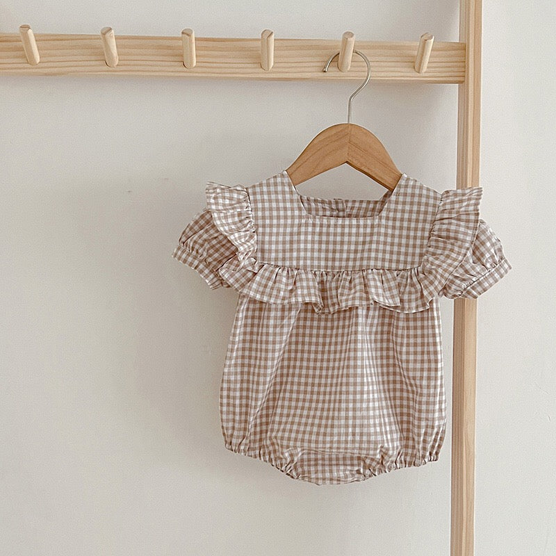 Baby girl wearing a plaid pattern square neck puff sleeves onesie and dress in blue, showcasing a stylish summer outfit.