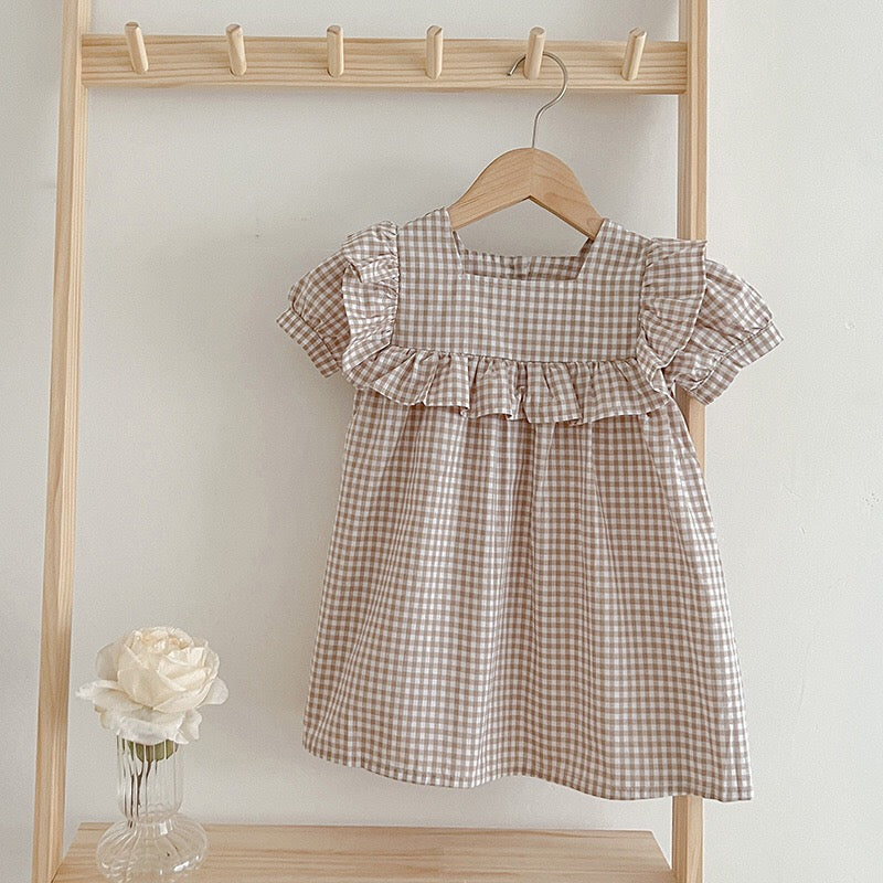 Baby girl wearing a plaid pattern square neck puff sleeves onesie and dress in blue, showcasing a stylish summer outfit.