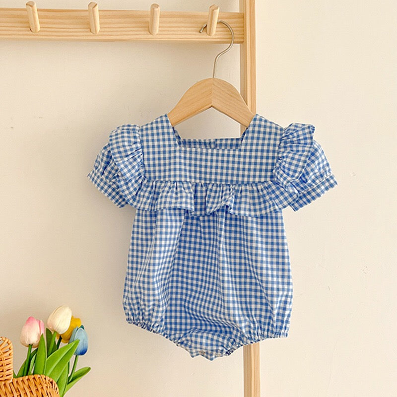 Baby girl wearing a plaid pattern square neck puff sleeves onesie and dress in blue, showcasing a stylish summer outfit.