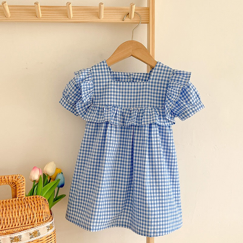 Baby girl wearing a plaid pattern square neck puff sleeves onesie and dress in blue, showcasing a stylish summer outfit.