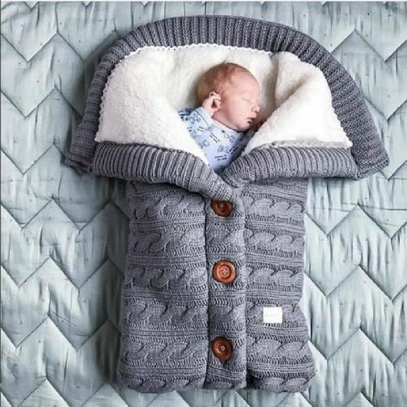 A cozy Baby Sleeping Bag Envelope in various colors, designed for infants, featuring a warm wool exterior and soft polar fleece lining.