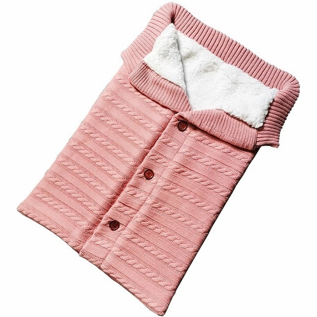 A cozy Baby Sleeping Bag Envelope in various colors, designed for infants, featuring a warm wool exterior and soft polar fleece lining.