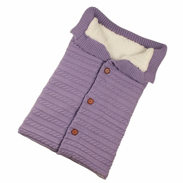 A cozy Baby Sleeping Bag Envelope in various colors, designed for infants, featuring a warm wool exterior and soft polar fleece lining.