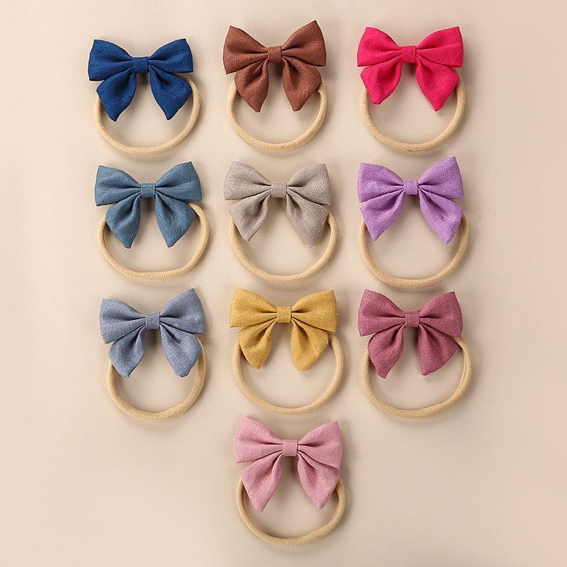 A collection of Baby Solid Color 3D Bow Handmade Elastic Headbands in various colors, showcasing their soft cotton material and adjustable design.