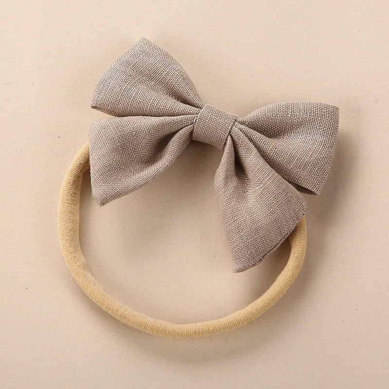 A collection of Baby Solid Color 3D Bow Handmade Elastic Headbands in various colors, showcasing their soft cotton material and adjustable design.