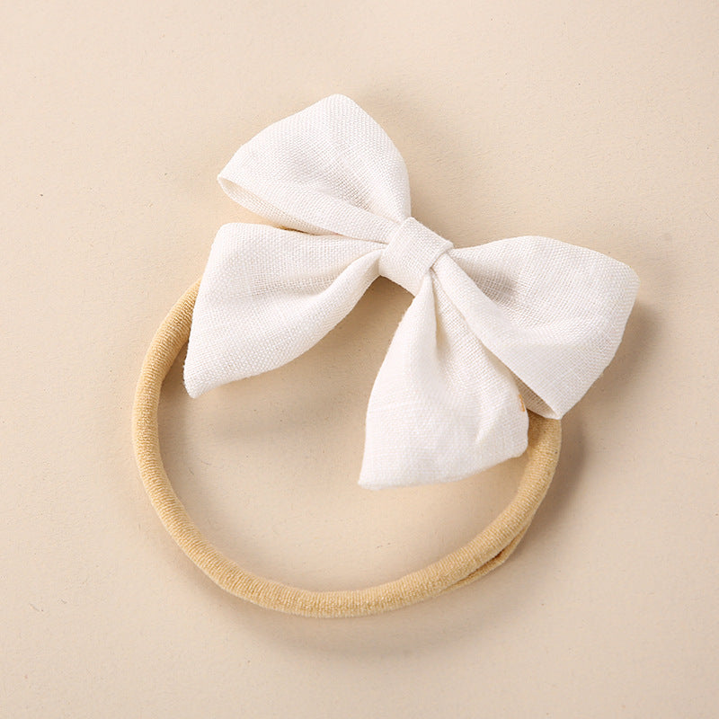 A collection of Baby Solid Color 3D Bow Handmade Elastic Headbands in various colors, showcasing their soft cotton material and adjustable design.