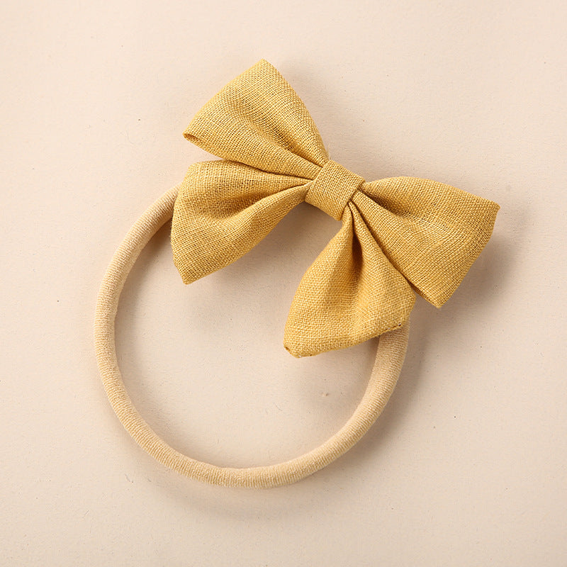 A collection of Baby Solid Color 3D Bow Handmade Elastic Headbands in various colors, showcasing their soft cotton material and adjustable design.