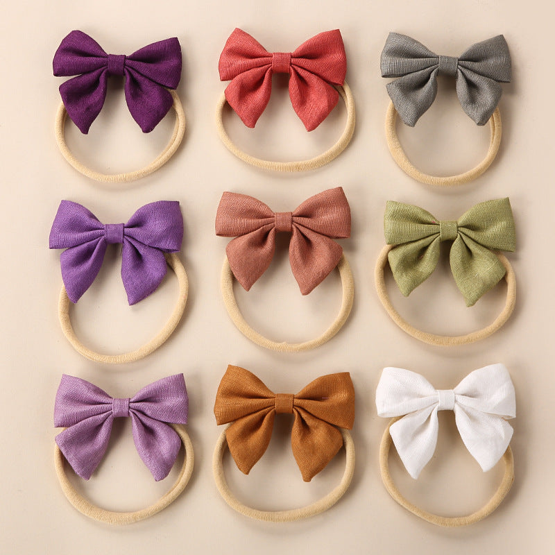 A collection of Baby Solid Color 3D Bow Handmade Elastic Headbands in various colors, showcasing their soft cotton material and adjustable design.