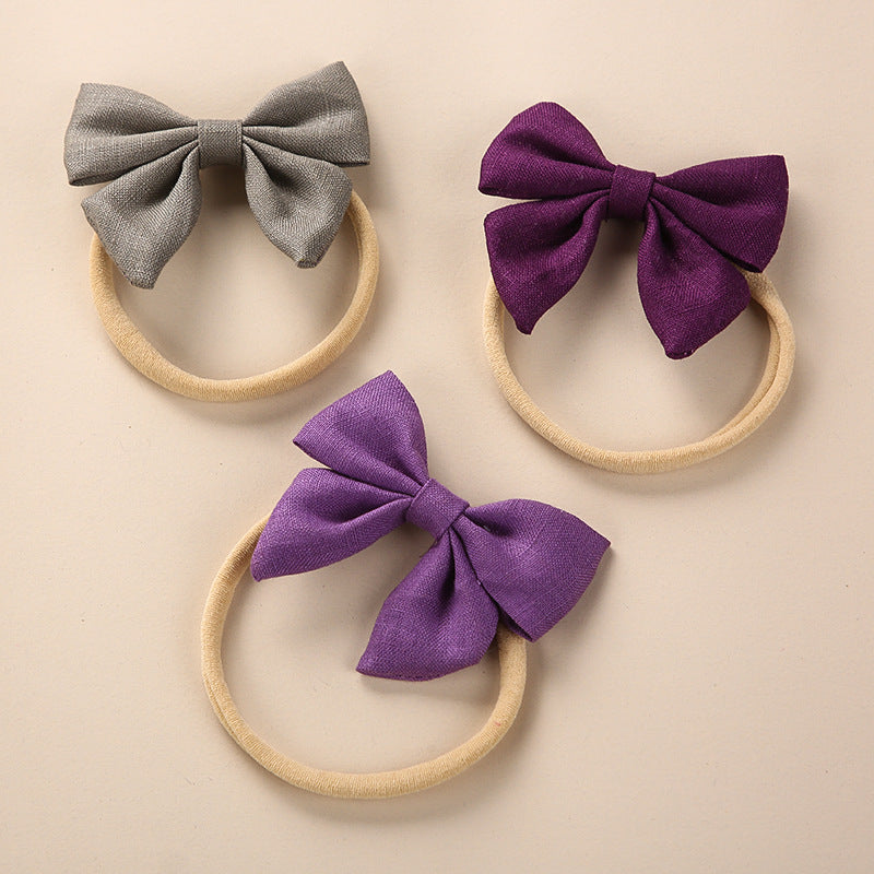 A collection of Baby Solid Color 3D Bow Handmade Elastic Headbands in various colors, showcasing their soft cotton material and adjustable design.