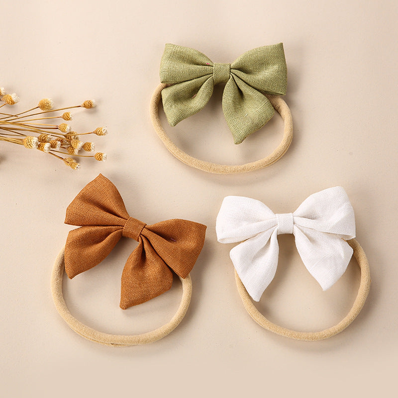 A collection of Baby Solid Color 3D Bow Handmade Elastic Headbands in various colors, showcasing their soft cotton material and adjustable design.