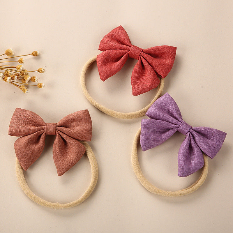 A collection of Baby Solid Color 3D Bow Handmade Elastic Headbands in various colors, showcasing their soft cotton material and adjustable design.