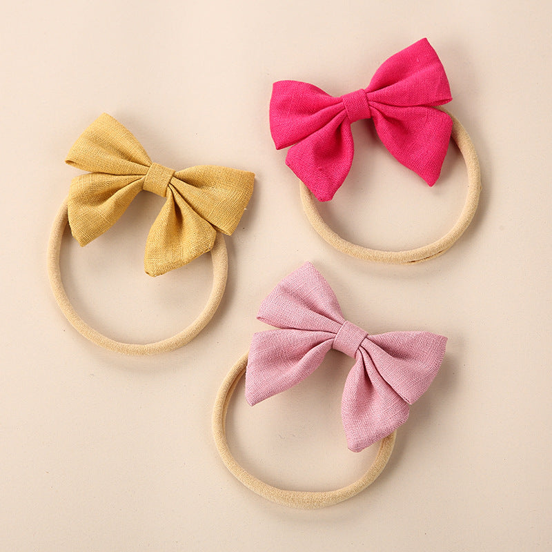 A collection of Baby Solid Color 3D Bow Handmade Elastic Headbands in various colors, showcasing their soft cotton material and adjustable design.