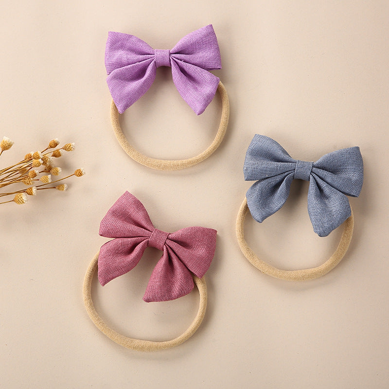 A collection of Baby Solid Color 3D Bow Handmade Elastic Headbands in various colors, showcasing their soft cotton material and adjustable design.