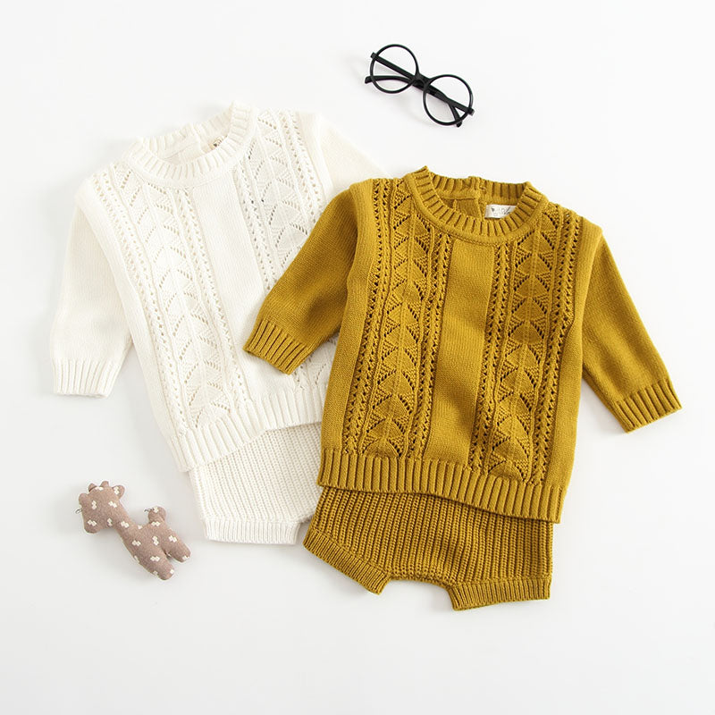 Baby girl wearing a solid color hollow carved knitwear set in white and yellow, showcasing a charming design.