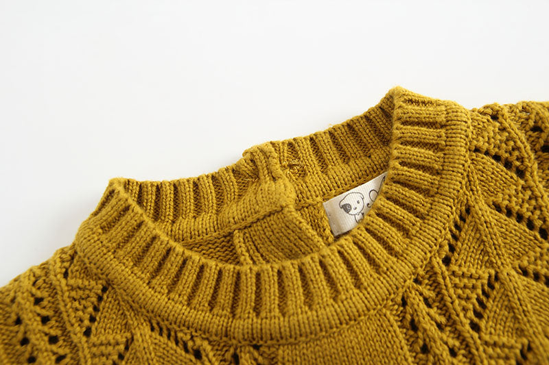 Baby girl wearing a solid color hollow carved knitwear set in white and yellow, showcasing a charming design.