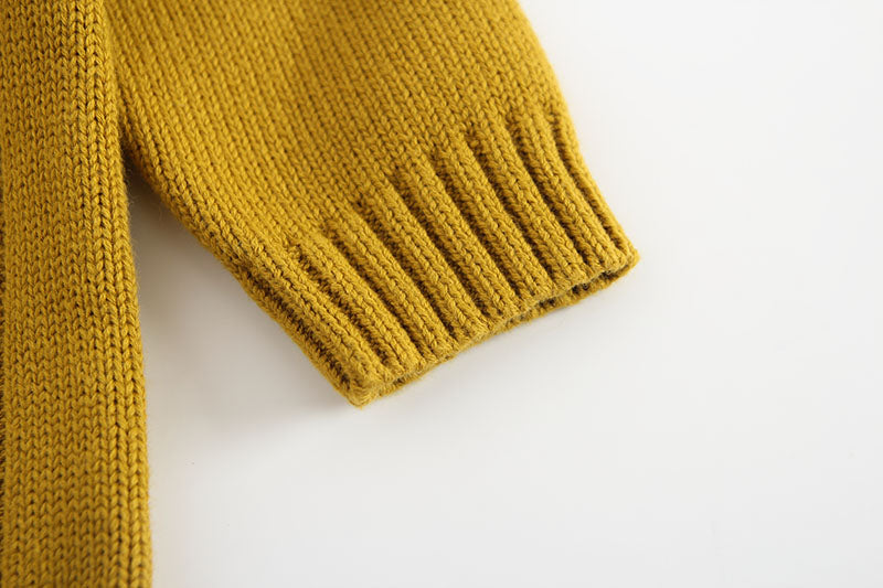 Baby girl wearing a solid color hollow carved knitwear set in white and yellow, showcasing a charming design.