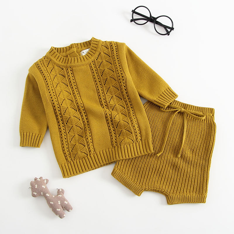 Baby girl wearing a solid color hollow carved knitwear set in white and yellow, showcasing a charming design.