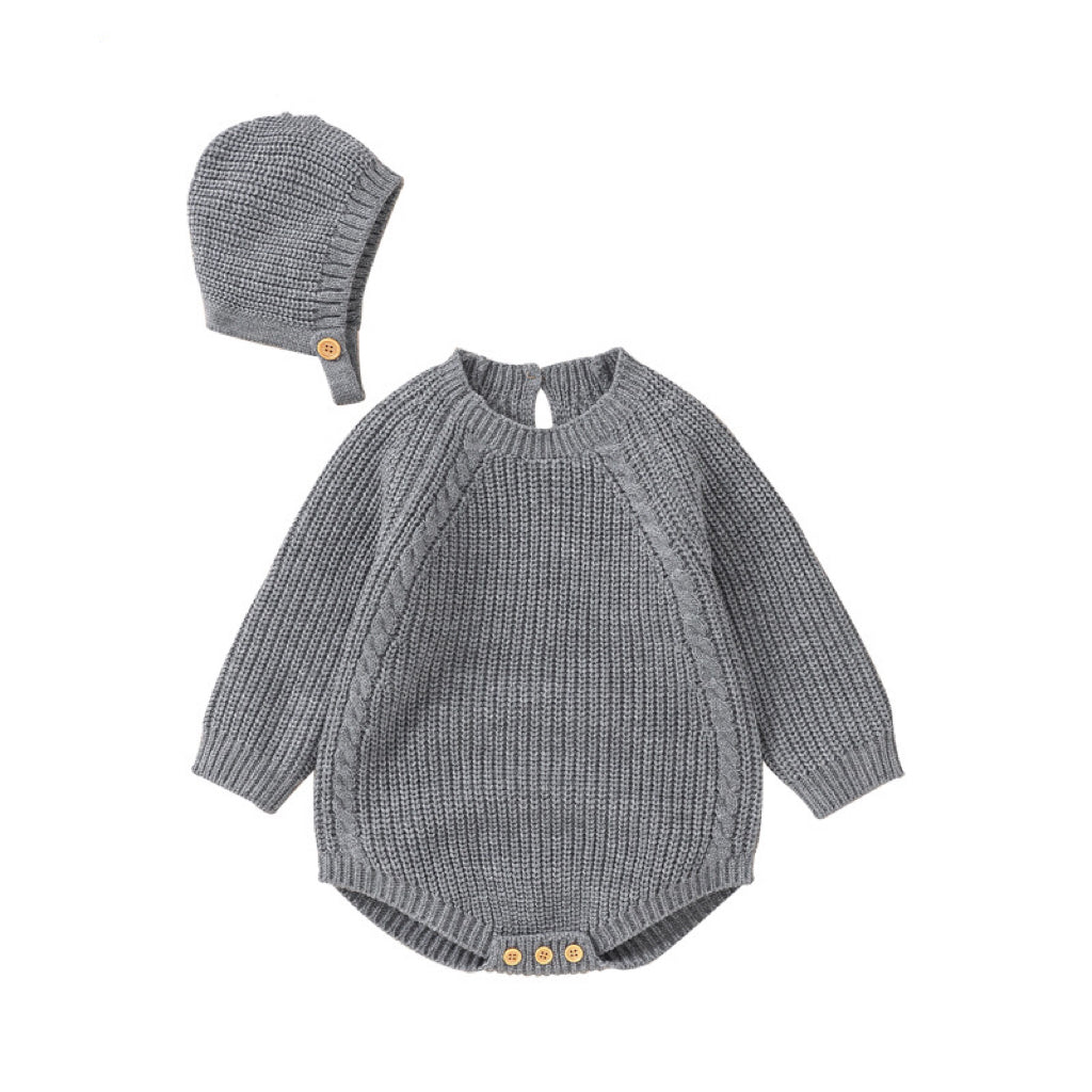 A cozy baby wearing a solid color long sleeve knitted woolen onesie in pink, showcasing its ribbed trim and snap-button closure.