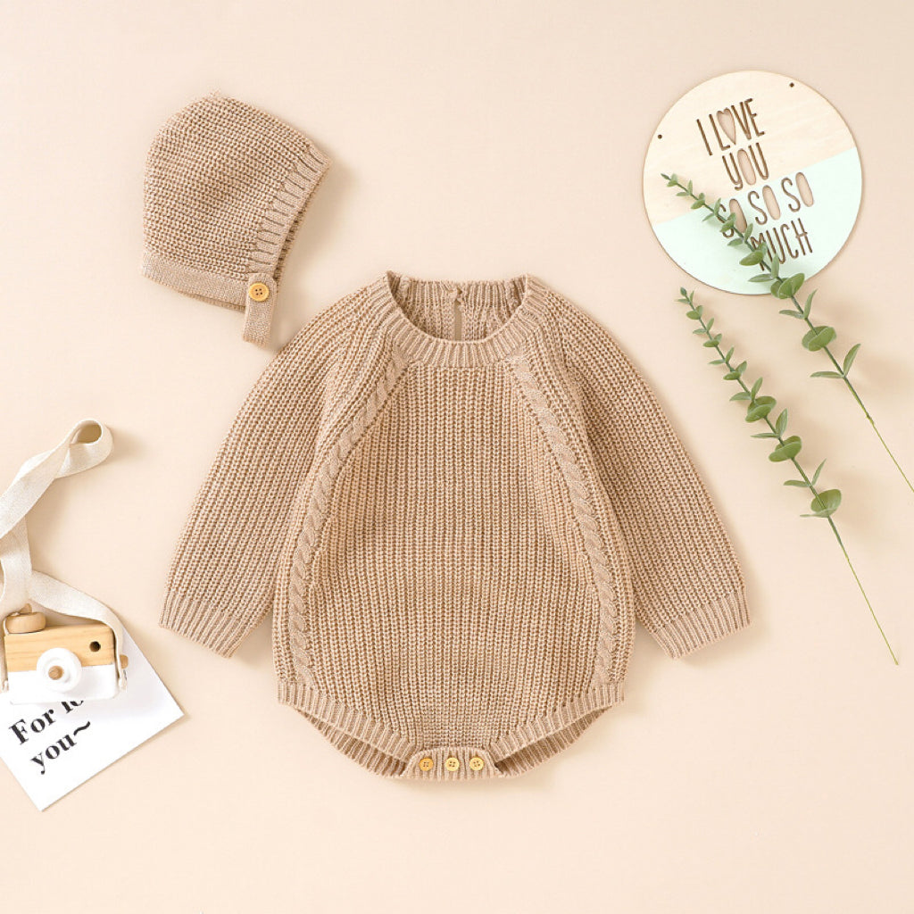 A cozy baby wearing a solid color long sleeve knitted woolen onesie in pink, showcasing its ribbed trim and snap-button closure.