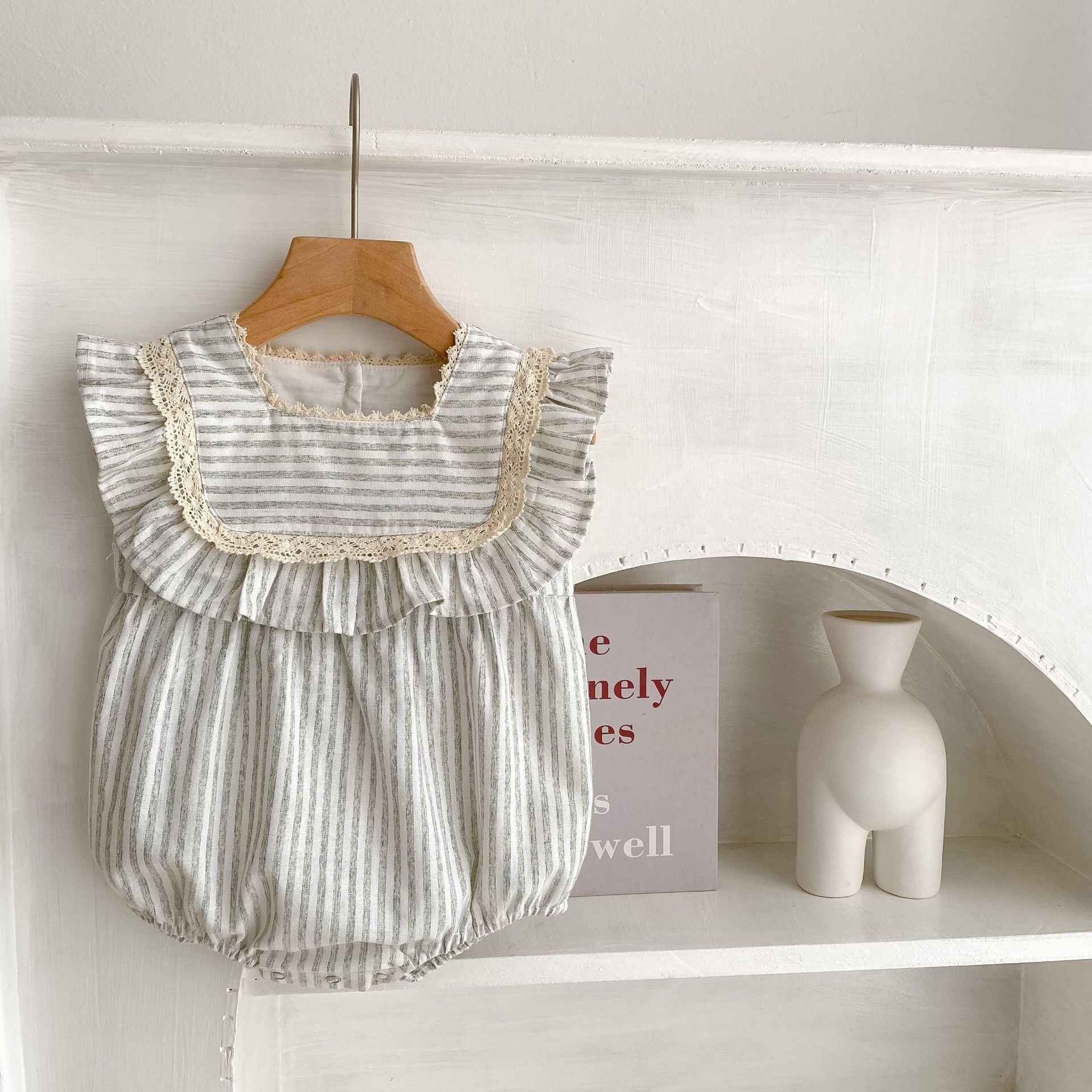 Baby girl wearing a striped sleeveless princess dress in green and light green, showcasing a playful summer style.